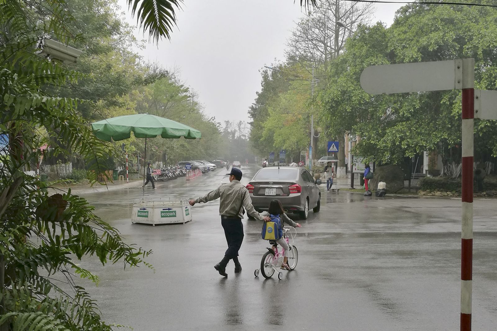 Nhân viên an ninh Ecopark giúp học sinh qua đường.